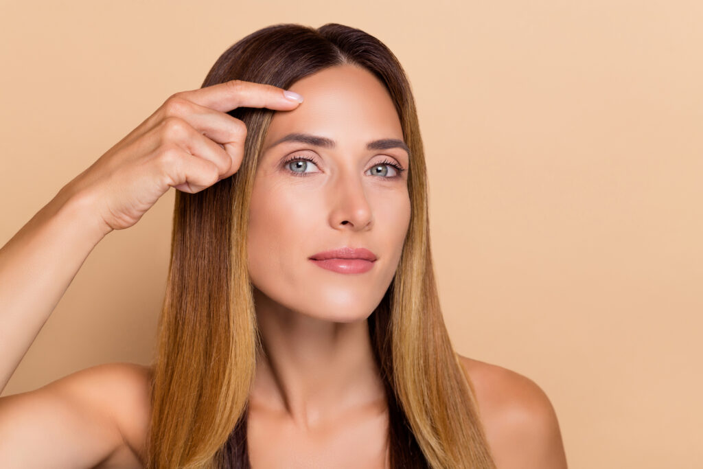 Pretty woman in her 40s has a smooth forehead thanks to Botox injections